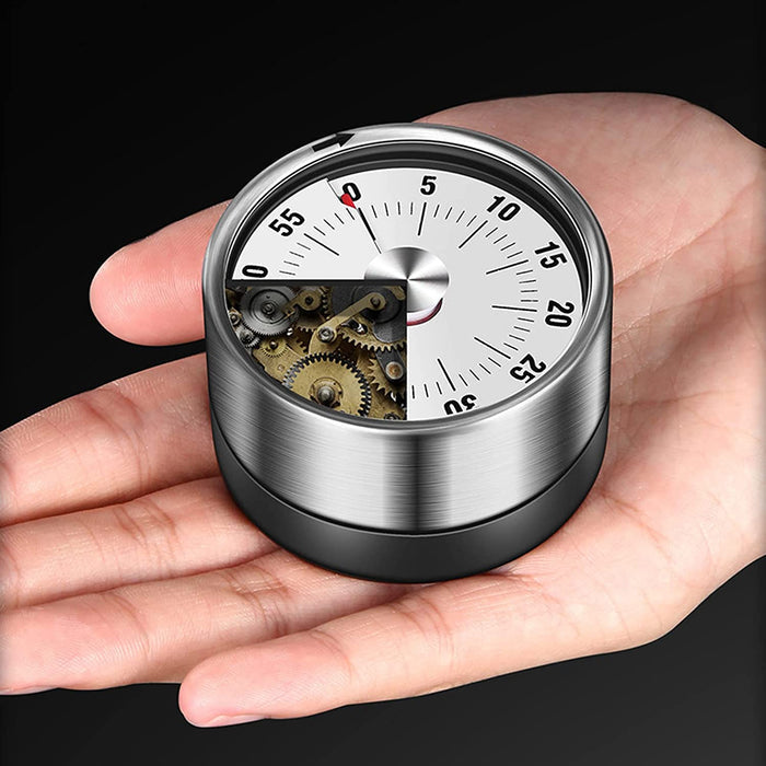A hand holding a magnetic mechanical 60-minute timer