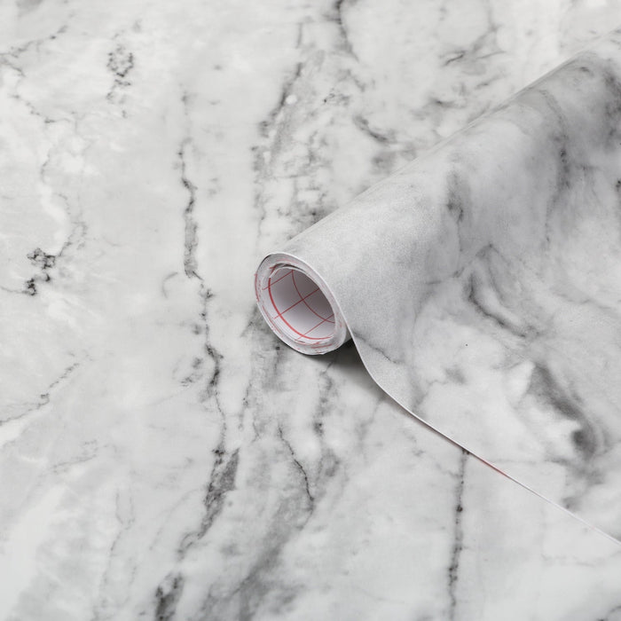 Roll of marble-patterned paper on a marble surface
