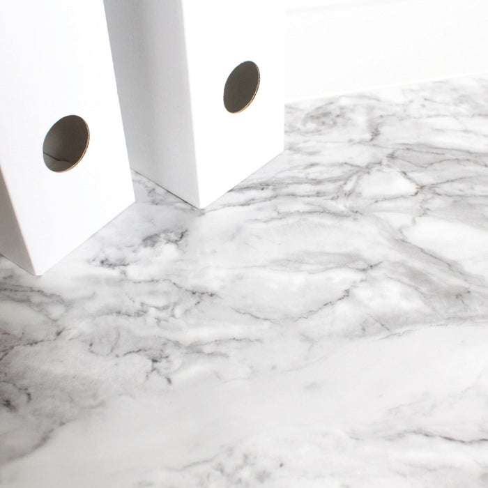 Close-up of a marble-patterned surface with white folders.