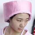 A lady enjoying a deep-conditioning session with a Multi-Purpose Electronic Hair Treatment Cap.
