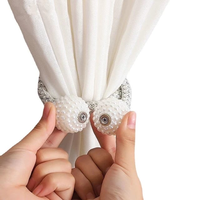 A person tying a curtain using Magnetic Curtain Binding Rope