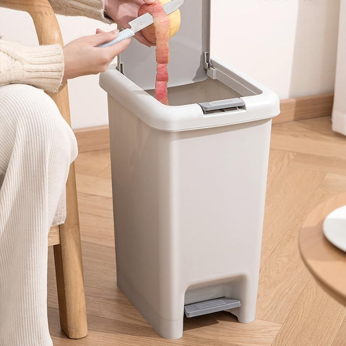 A person is peeling apple wastes in to Pedal Trash Bin.