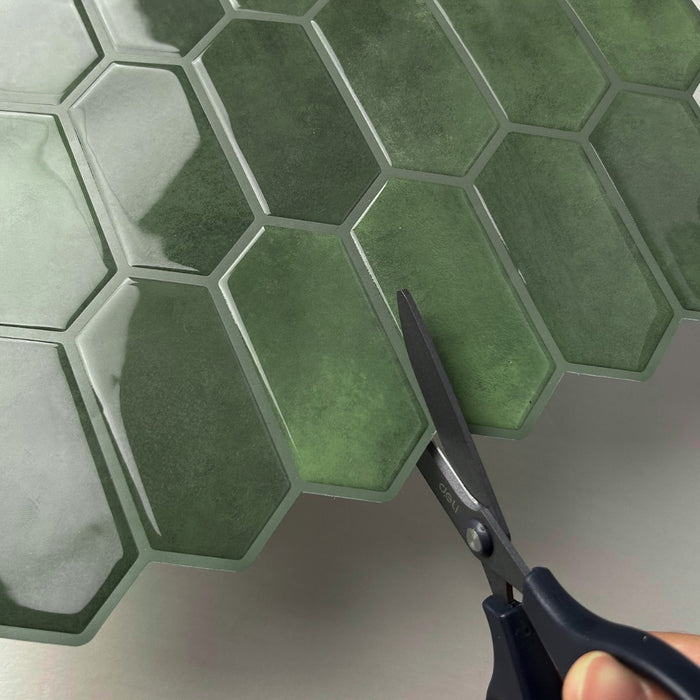 Green hexagonal tiles with a pair of scissors on a white background