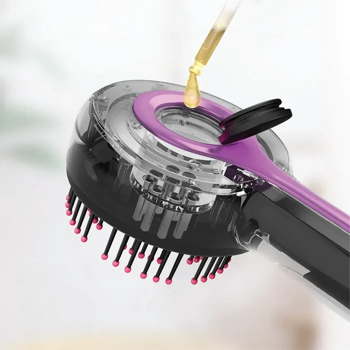 orodo red light therapy scalp massage comb is shown in close-up, featuring soft bristles with rounded tips and a transparent chamber at the top. A dropper is adding liquid (likely hair oil or serum) into the comb’s built-in reservoir through an open cap.