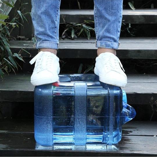 A Person is Standing On the Portable Water Tank Container Can.