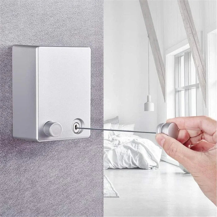a hand holding a Retractable Wire Indoor and Outdoor Clothes Wall Hanger