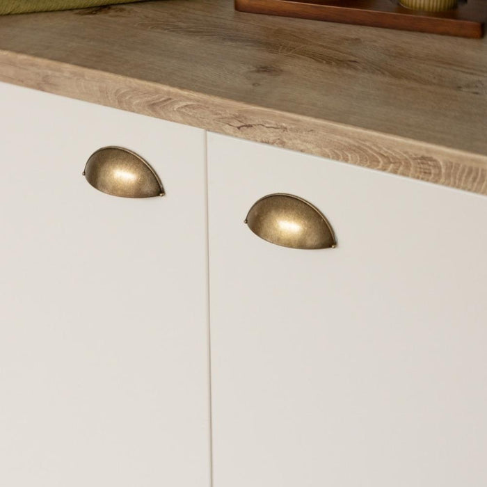 A beige-colored matte adhesive vinyl roll applied on a flat surface, representing a kitchen cabinet.