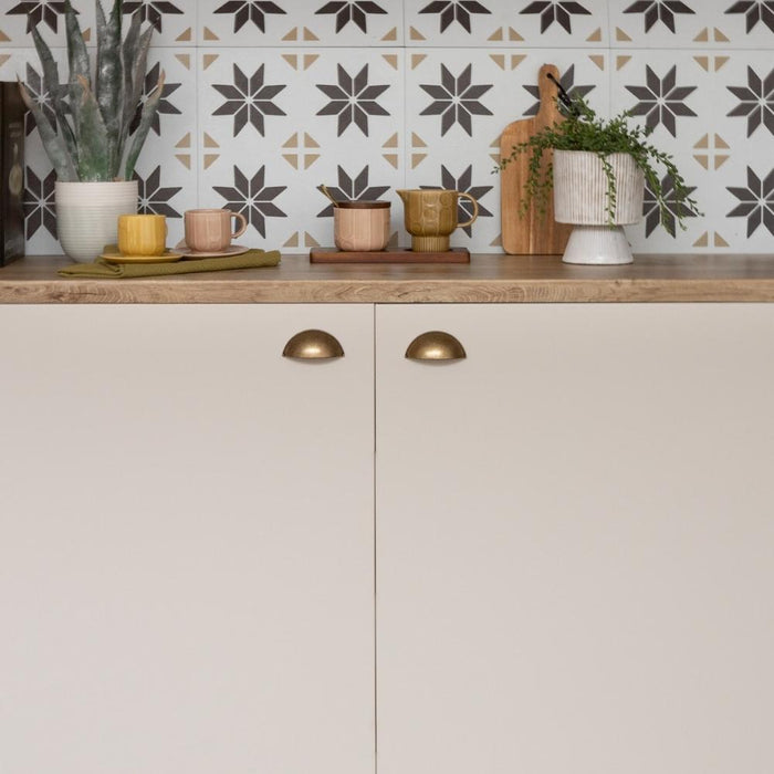 sand matte vinyl wrapped cupboard with a brown and beige tile splash back with stars.