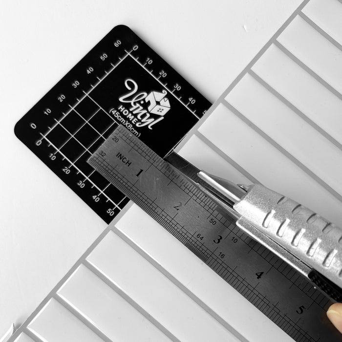 Vinyl cutting mat with ruler and scissors on a white surface