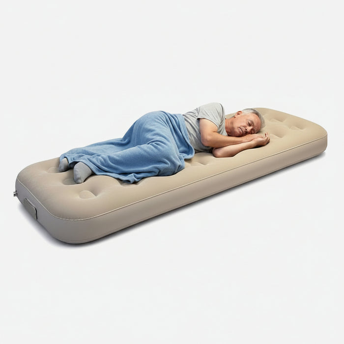 Person sleeping on an inflatable bed with a compact storage bag next to it on a white background