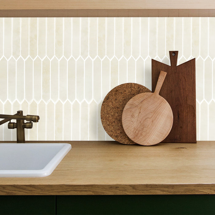 Wooden cutting boards on a kitchen counter with a geometric tile backsplash.