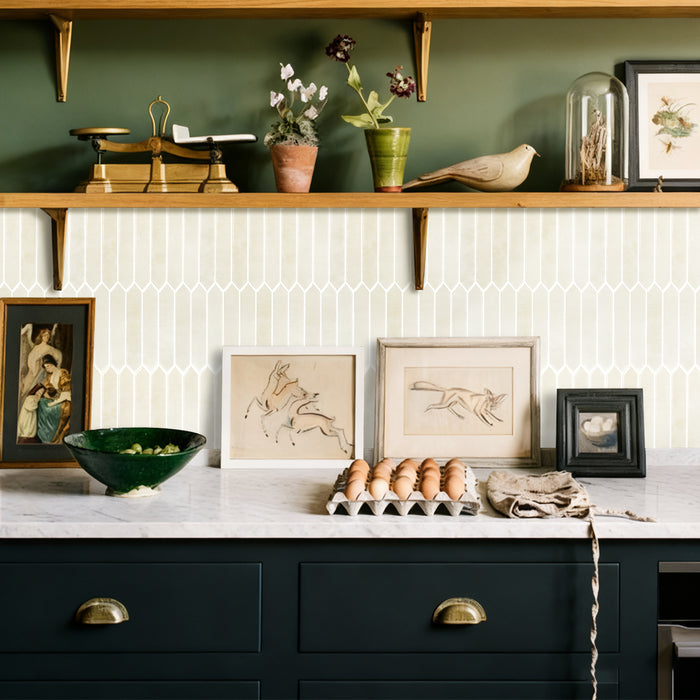 Kitchen counter with decorative items including a bowl, eggs, and framed art on a tiled wall.