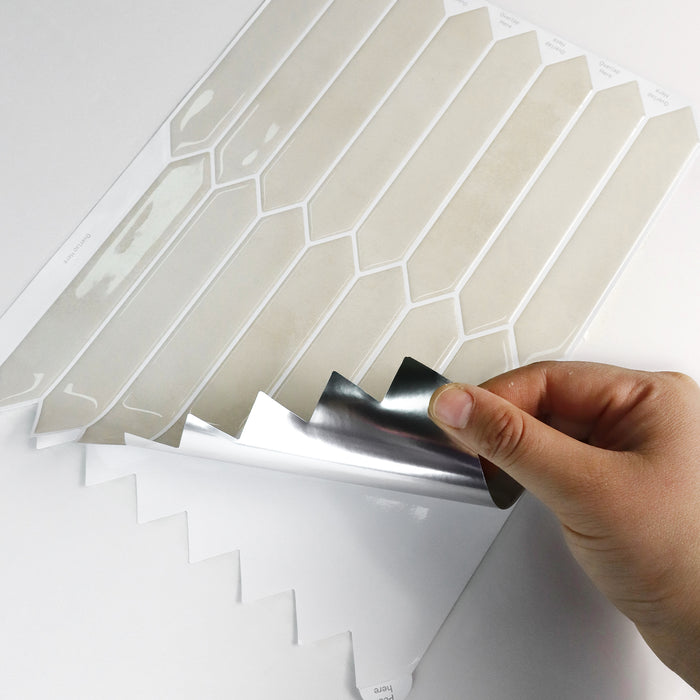 Hand applying a decorative sandy picket tile sheet with geometric pattern to a surface.