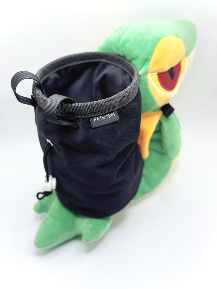 A cute, handmade plush climbing chalk bag designed to look like the Snivy, featuring a sleek green and cream body with yellow leaf-like accents and large, confident eyes. Designed with high functionality by a climber, it includes a wide black rim opening at the top for easy chalk access. A great climbing gift for trainers who want to catch them all.