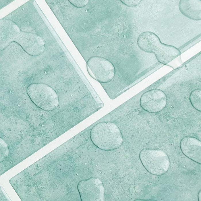 Mint green textured tiles with a raised water drops and white grout lines.