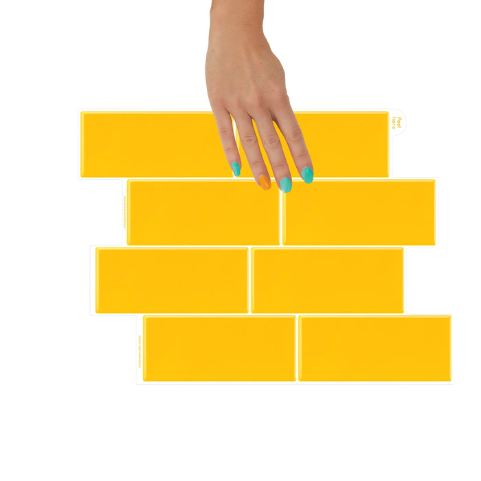 Yellow tiles arranged in a pattern with a hand placing one tile on top.