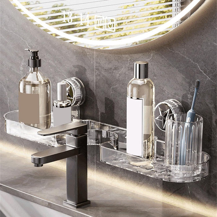 Clear suction bathroom shelf mounted on a tiled bathroom wall above a sink, holding soap dispensers, skincare bottles, and a toothbrush holder beside a modern black faucet.