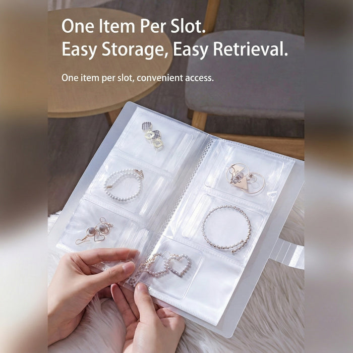 A person is holding  transparent jewelry storage book with multiple clear pocket sleeves displaying neatly organized earrings, bracelets, and rings.