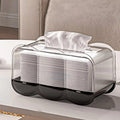 Black Wave shaped transparent tissue box on a table,with one tissue pulled up and ready for use.
