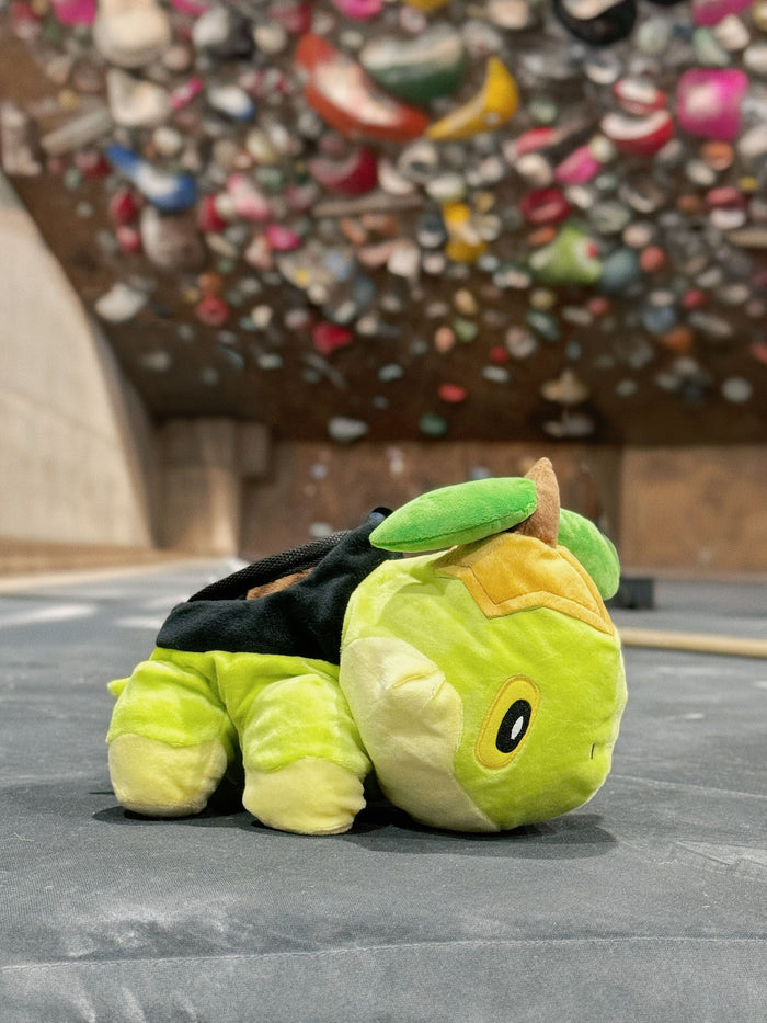 A soft and fluffy Turtwig plush chalk bag by Fatworm. This cute yet functional bouldering bag features a long-durable design and character-inspired details, making it the perfect climbing gift for climbers who love unique, handmade accessories.
