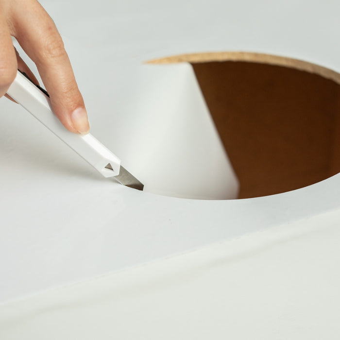 White glossy adhesive vinyl being cut in a circle