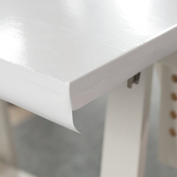Edge of a board that is covered with white glossy adhesive vinyl