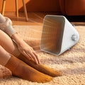 A Person is Sitting Infront Of Winning Star Portable Space Heater.